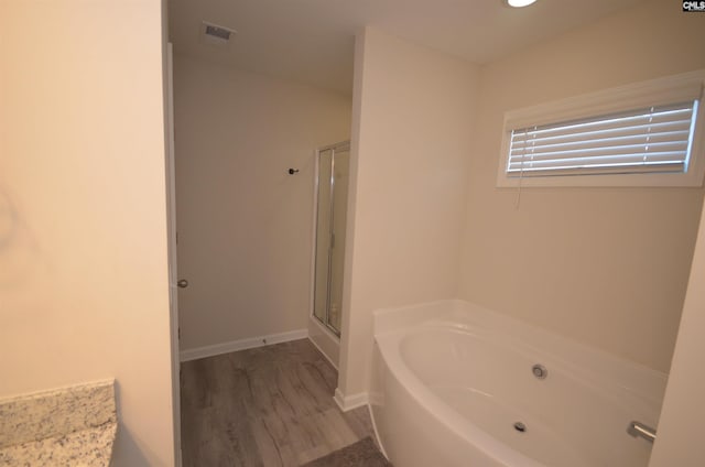 bathroom featuring hardwood / wood-style flooring and shower with separate bathtub