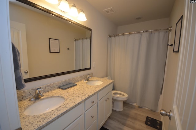 bathroom with hardwood / wood-style floors, vanity, toilet, and a shower with curtain