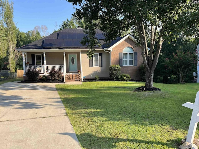 ranch-style house with solar panels, covered porch, and a front lawn