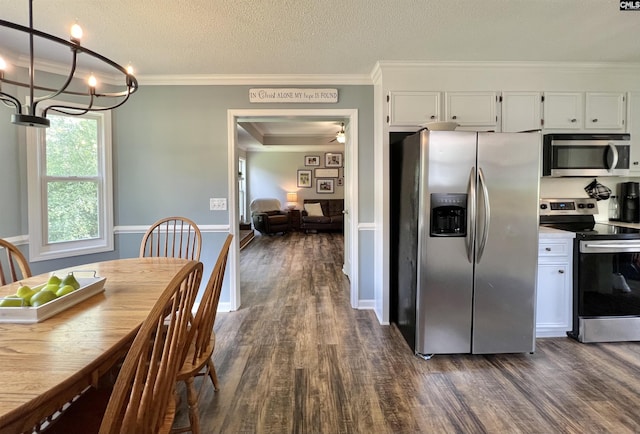 kitchen featuring hanging light fixtures, dark hardwood / wood-style flooring, a textured ceiling, white cabinets, and appliances with stainless steel finishes