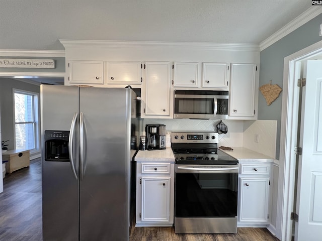 kitchen featuring tasteful backsplash, stainless steel appliances, dark wood-type flooring, crown molding, and white cabinetry