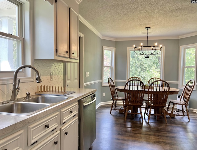 kitchen with an inviting chandelier, sink, hanging light fixtures, stainless steel dishwasher, and decorative backsplash