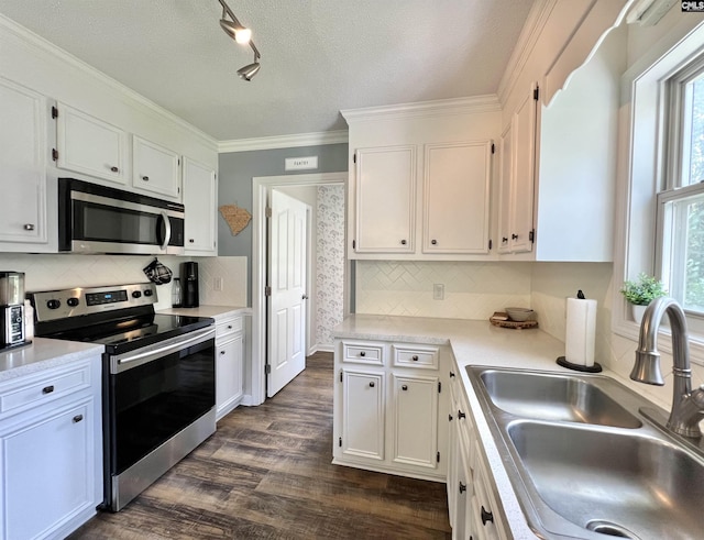 kitchen featuring tasteful backsplash, white cabinetry, sink, and appliances with stainless steel finishes