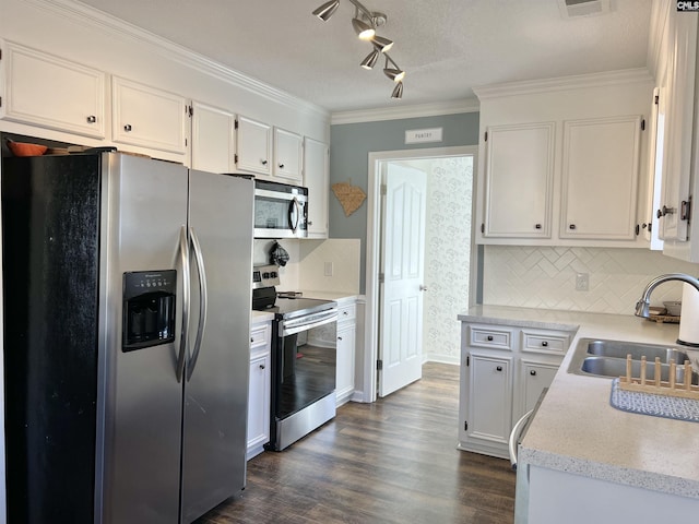 kitchen with crown molding, sink, decorative backsplash, appliances with stainless steel finishes, and white cabinetry