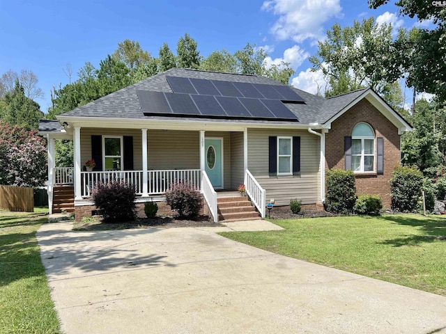 view of front facade featuring solar panels, covered porch, and a front yard