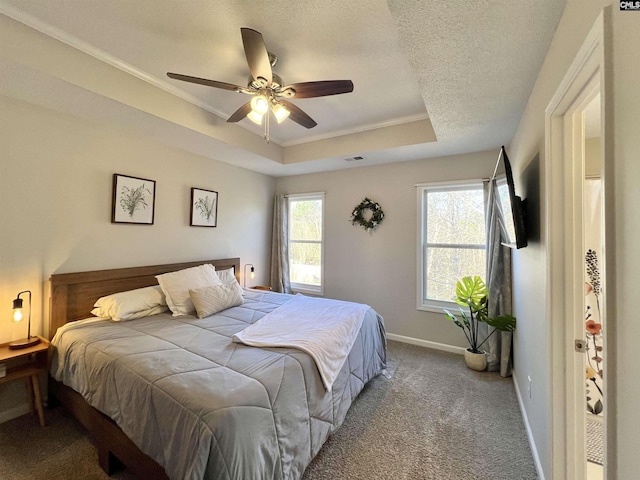 carpeted bedroom featuring a textured ceiling, a tray ceiling, ceiling fan, and crown molding