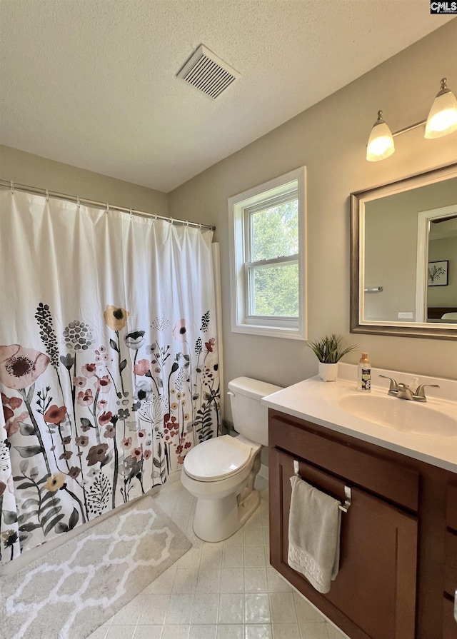 bathroom featuring a shower with shower curtain, vanity, toilet, and a textured ceiling