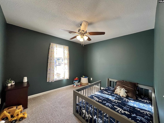 carpeted bedroom featuring ceiling fan and a textured ceiling