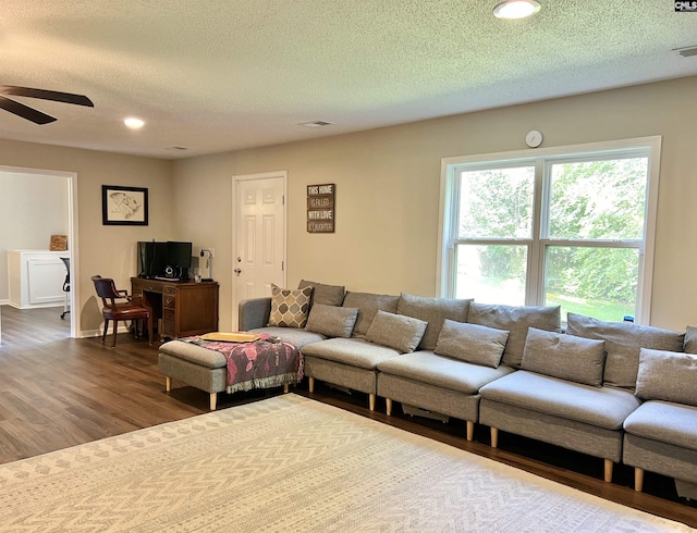 living room with hardwood / wood-style floors, a textured ceiling, and ceiling fan