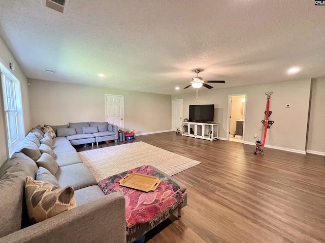 living room with ceiling fan, a textured ceiling, and hardwood / wood-style flooring