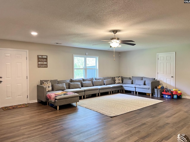 living room featuring a textured ceiling, ceiling fan, and dark wood-type flooring