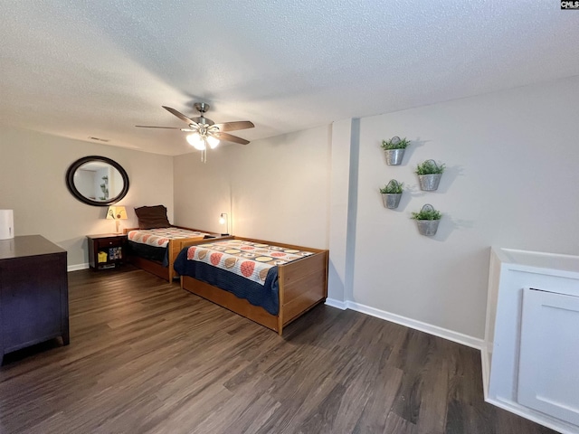 bedroom featuring a textured ceiling, ceiling fan, and dark wood-type flooring