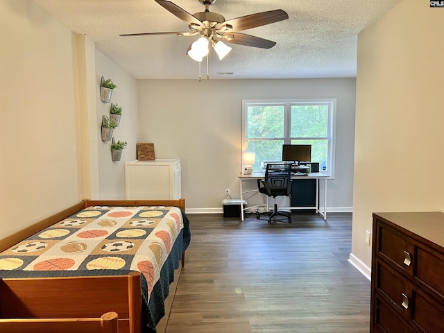 bedroom with ceiling fan, dark hardwood / wood-style flooring, and a textured ceiling