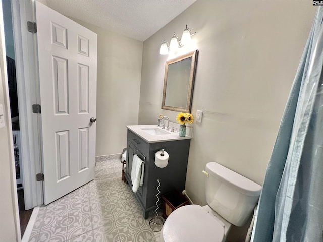 bathroom with vanity, toilet, and a textured ceiling