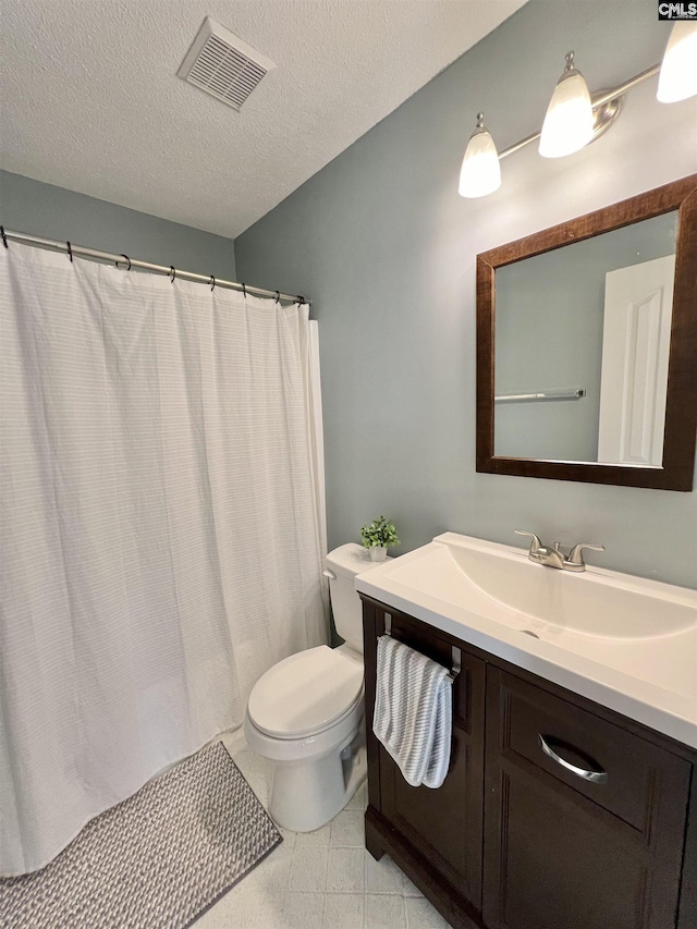 bathroom with vanity, a textured ceiling, and toilet