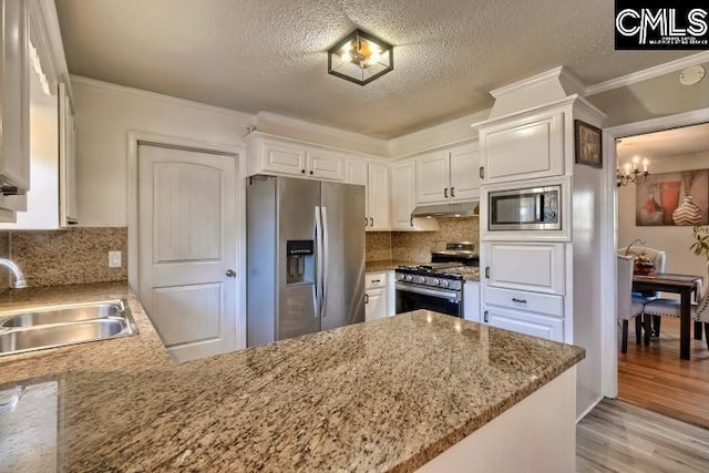 kitchen featuring white cabinets, appliances with stainless steel finishes, kitchen peninsula, and sink