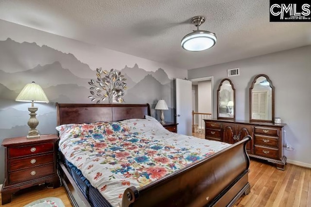 bedroom featuring light hardwood / wood-style flooring and a textured ceiling