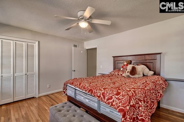 bedroom featuring ceiling fan, light wood-type flooring, a textured ceiling, and a closet