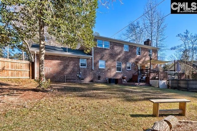 back of property with a lawn, a wooden deck, and central air condition unit