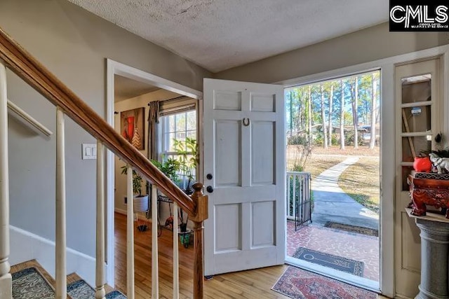 foyer entrance featuring a textured ceiling and light hardwood / wood-style floors