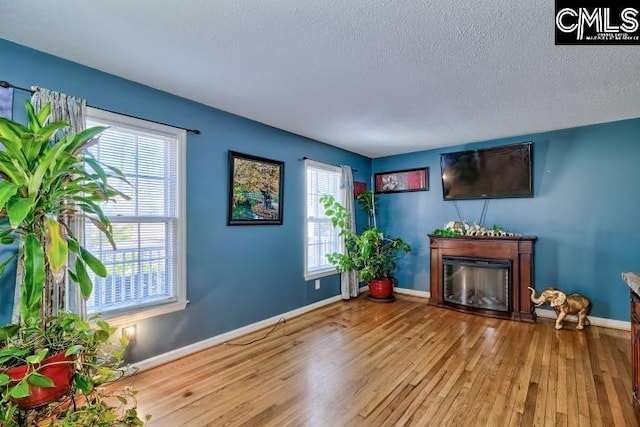 unfurnished living room featuring hardwood / wood-style floors and a textured ceiling