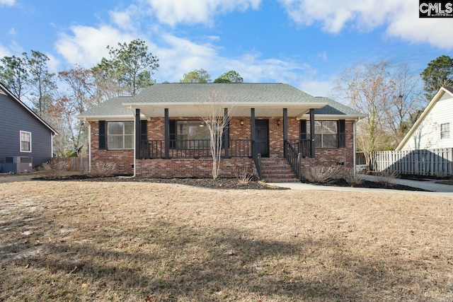 view of front of property featuring covered porch, a front lawn, and cooling unit