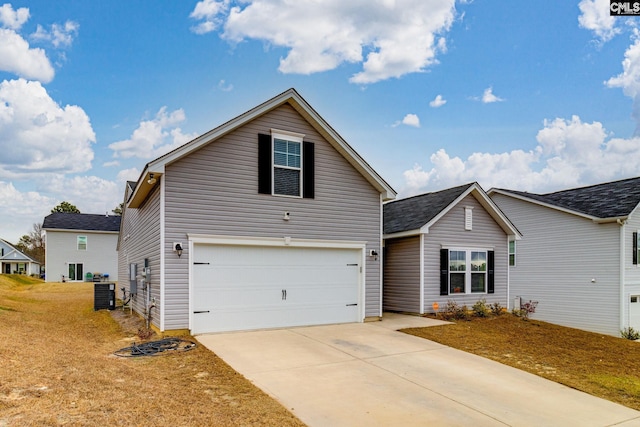 front facade with cooling unit, a garage, and a front yard