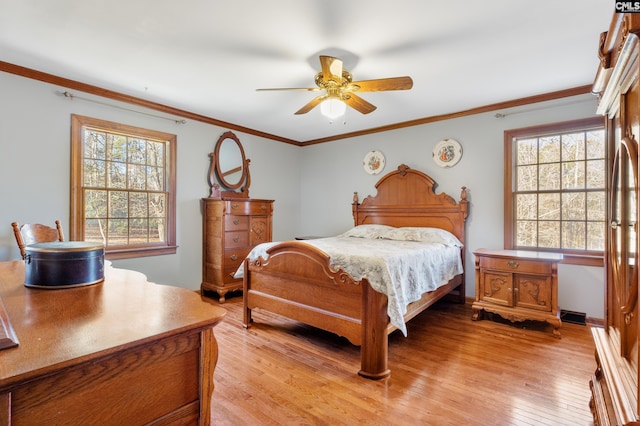 bedroom featuring ceiling fan, light hardwood / wood-style floors, ornamental molding, and multiple windows