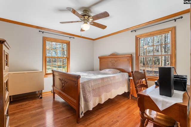 bedroom with ceiling fan, light hardwood / wood-style floors, and crown molding