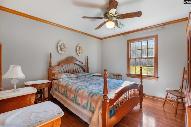 bedroom with hardwood / wood-style floors, ceiling fan, and crown molding