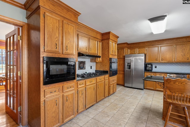 kitchen with black appliances, light tile patterned flooring, and backsplash