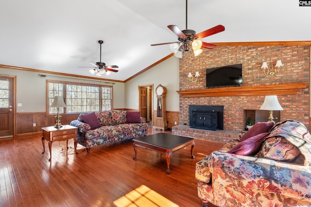 living room featuring ceiling fan, crown molding, lofted ceiling, a fireplace, and hardwood / wood-style flooring