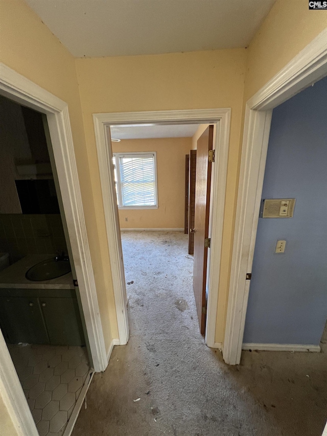 hallway featuring carpet floors and sink