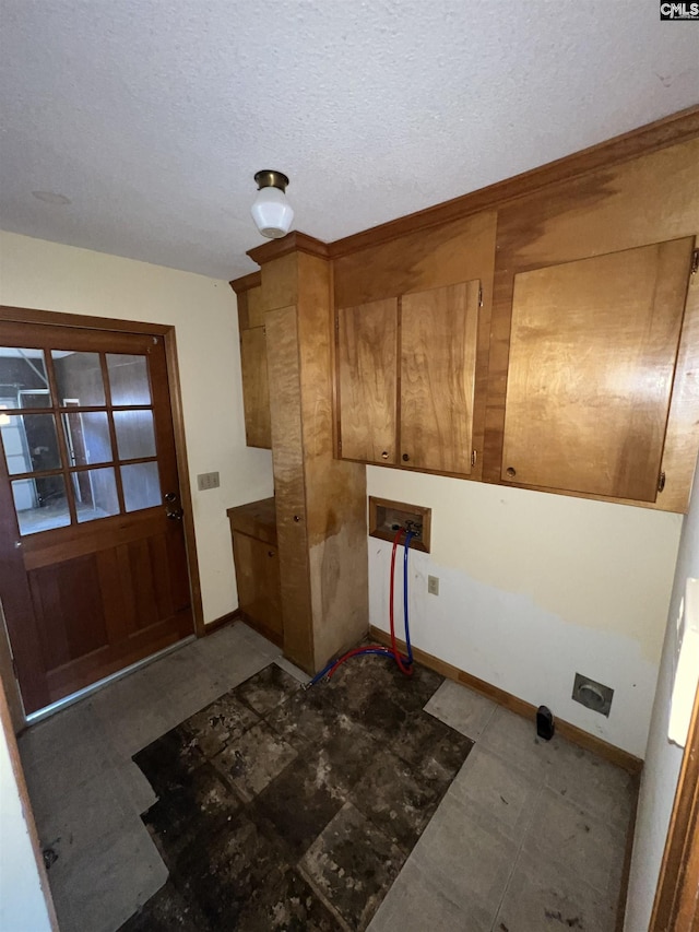 laundry area with electric dryer hookup, cabinets, a textured ceiling, and hookup for a washing machine