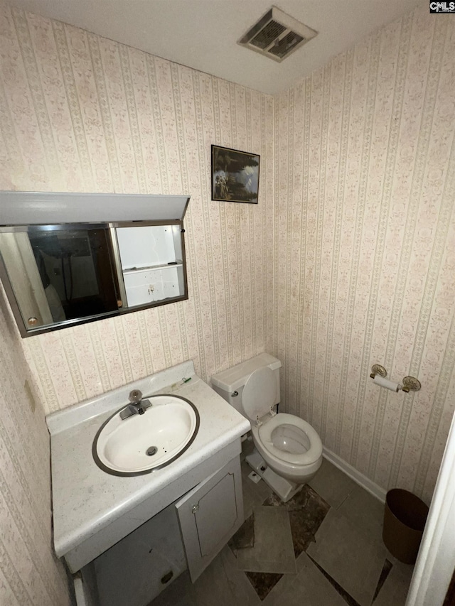 bathroom featuring tile patterned flooring, vanity, and toilet