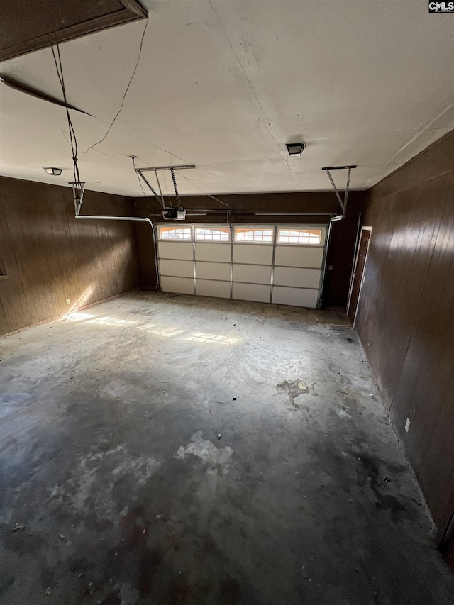 garage featuring wood walls and a garage door opener