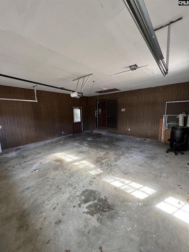 garage with a garage door opener and wooden walls