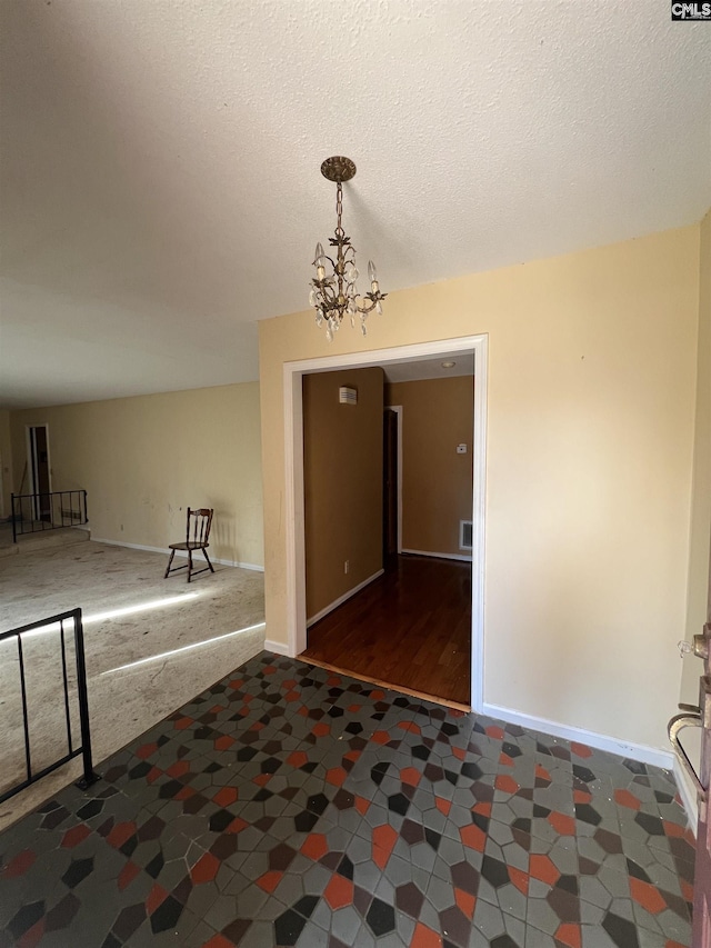 entrance foyer featuring a notable chandelier and a textured ceiling