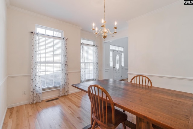 dining area featuring an inviting chandelier, light hardwood / wood-style flooring, and ornamental molding