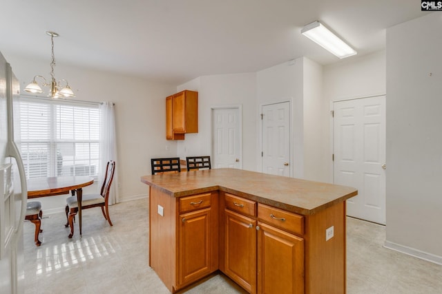 kitchen with decorative light fixtures, a kitchen island, and an inviting chandelier