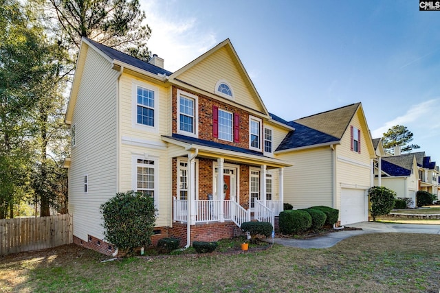 view of front of home featuring a front yard, a porch, and a garage