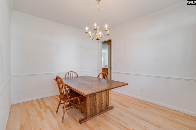 dining area with ornamental molding, light wood-type flooring, and a notable chandelier