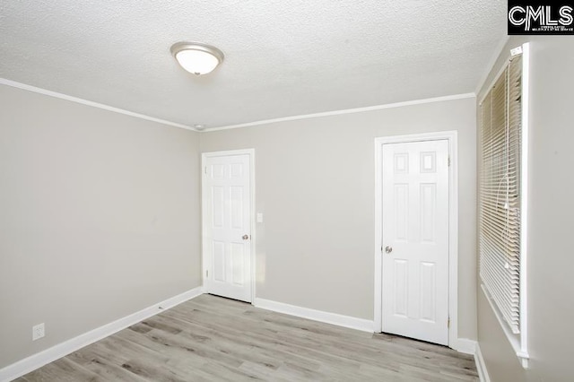 unfurnished bedroom with a textured ceiling, light hardwood / wood-style flooring, and crown molding