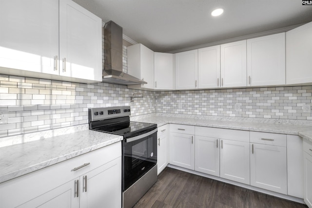 kitchen featuring stainless steel range with electric stovetop, white cabinetry, wall chimney range hood, and backsplash