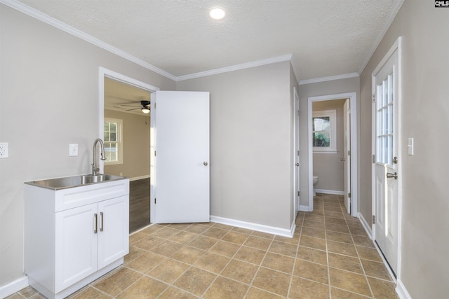 interior space featuring a wealth of natural light, ceiling fan, sink, a textured ceiling, and white cabinets