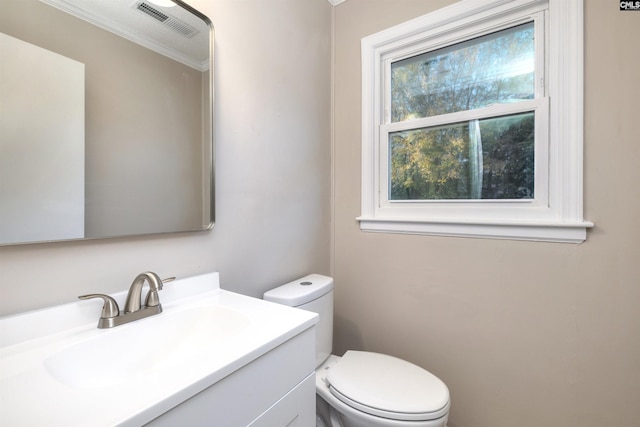 bathroom featuring crown molding, vanity, and toilet