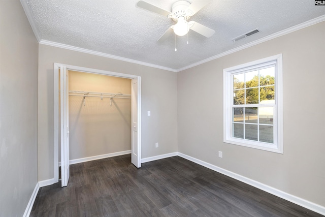 unfurnished bedroom with ceiling fan, dark hardwood / wood-style floors, a textured ceiling, a closet, and ornamental molding