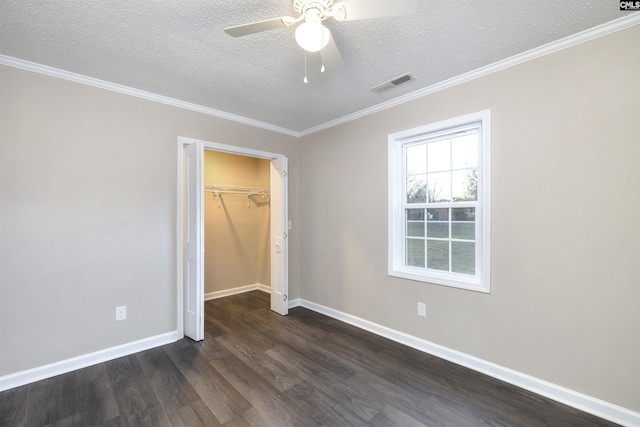 unfurnished bedroom with dark hardwood / wood-style flooring, a textured ceiling, ceiling fan, crown molding, and a closet