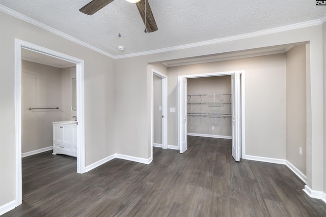 unfurnished bedroom featuring ceiling fan, dark hardwood / wood-style flooring, crown molding, a textured ceiling, and a closet