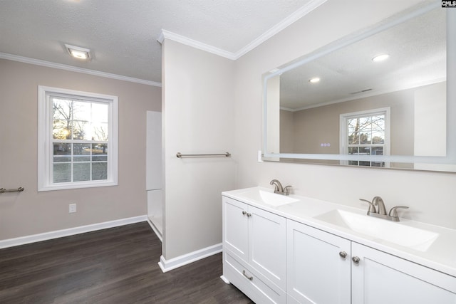 bathroom with vanity, a textured ceiling, hardwood / wood-style flooring, and ornamental molding